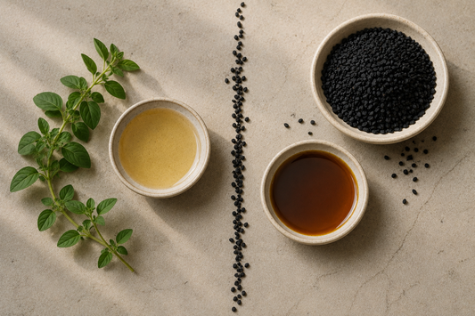 Fresh oregano and golden oil on one side, black seeds and amber oil on the other