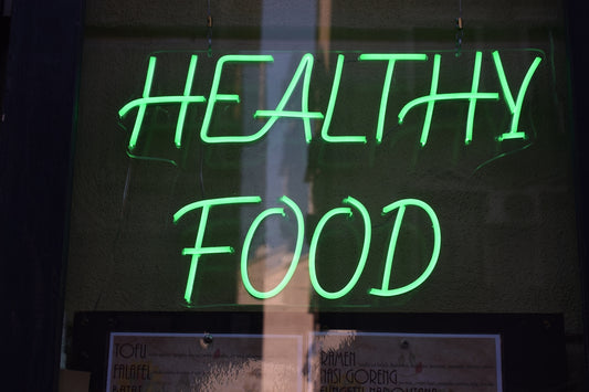 a green neon sign that says healthy food