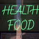a green neon sign that says healthy food
