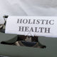 a close up of a typewriter with a paper that reads holstic health