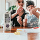 two women sitting at a table with a box of water