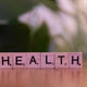 A wooden block spelling the word health on a table