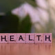 A wooden block spelling the word health on a table