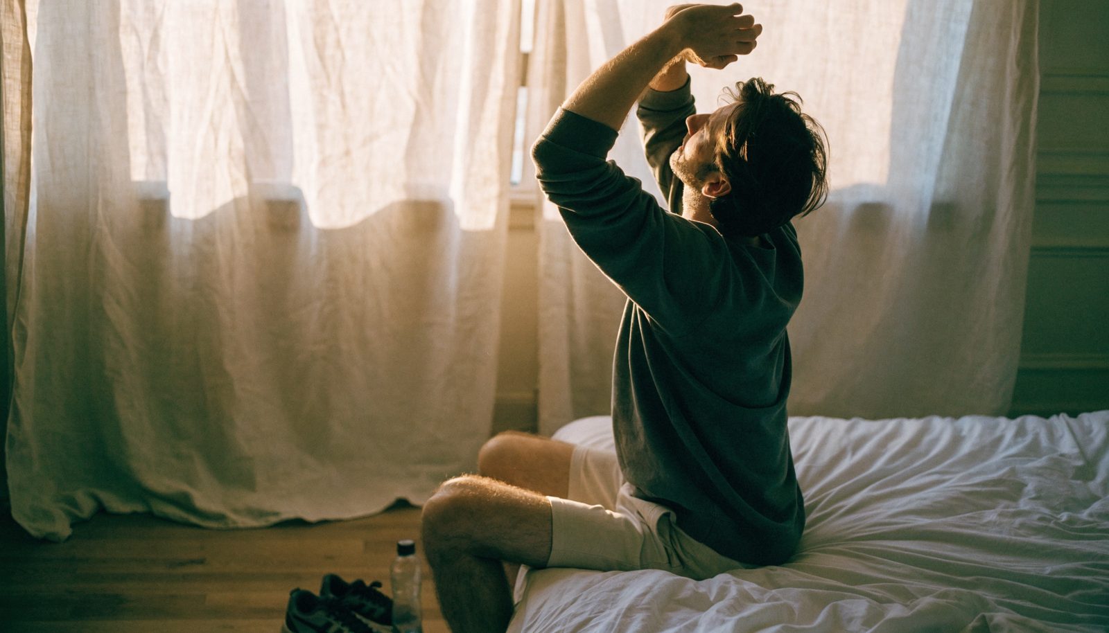 Man stretching at sunrise, rested and energised